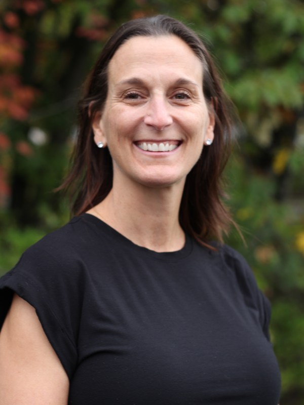 Michelle Blake - a woman with medium black hair smiling, wearing a black top