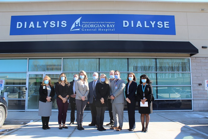 10 staff members and guest stand outside a glass fronted building with a Dialysis Georgian Bay General Hospital sign.