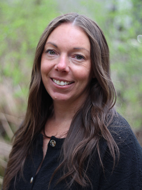 Janine Duquette - a woman with long brown hair wearing a black top