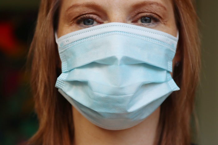 Close up of blue eyed woman wearing a medical mask