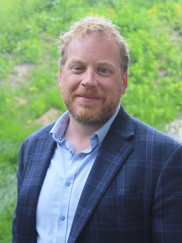 Matthew Lawson - man with strawberry blond hair and beard in a blue blazer and shirt